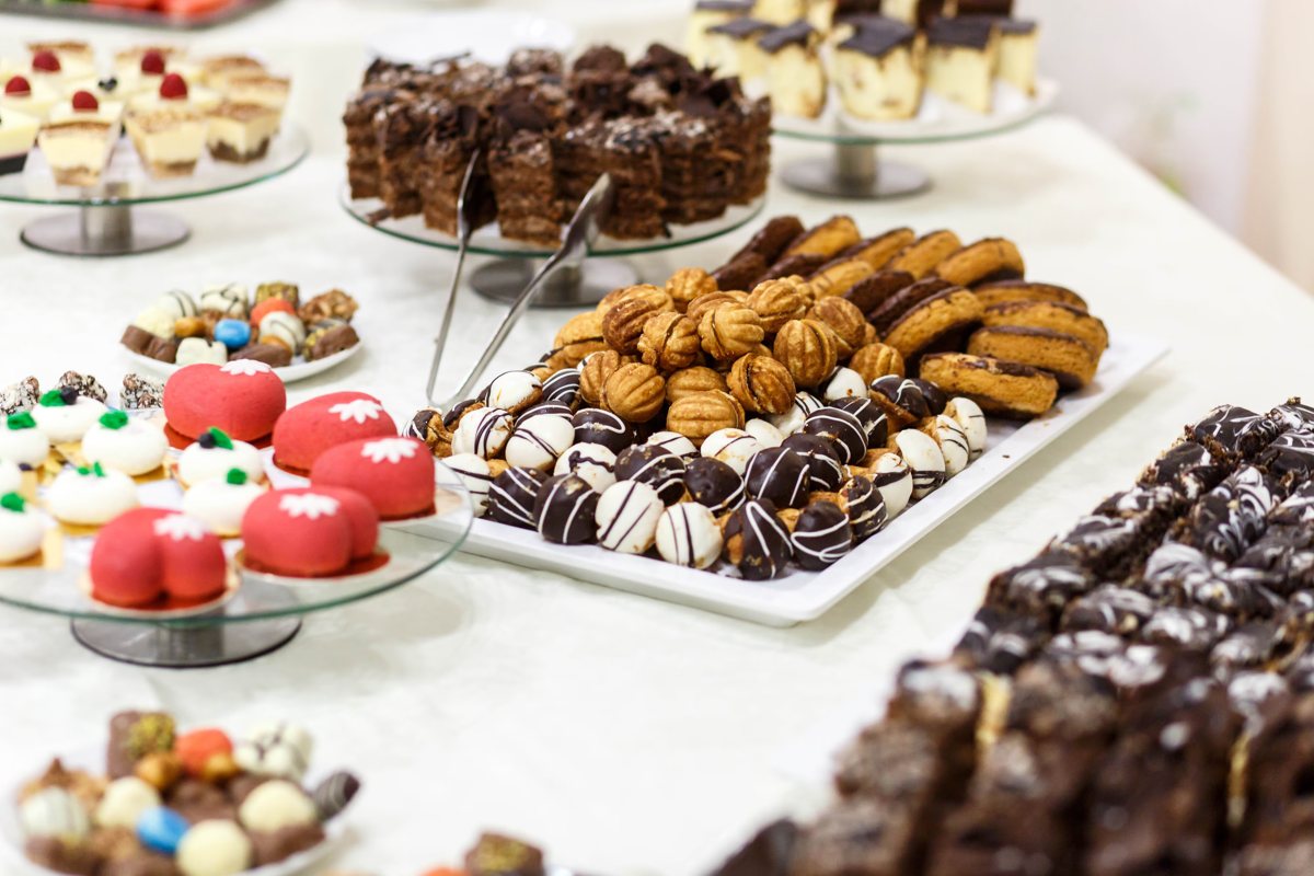 Mesa de festa com doces finos, bombons e docinhos em bandejas